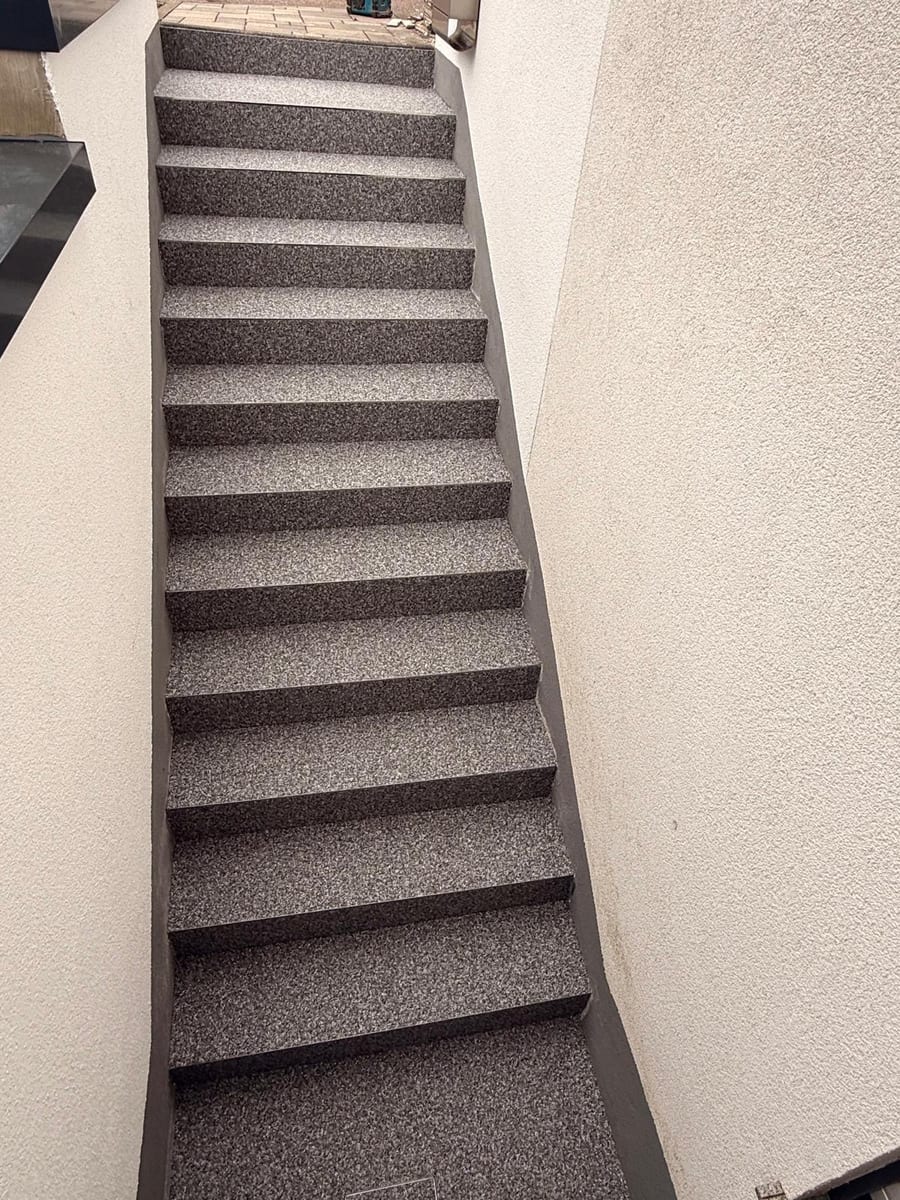 Dieselbe Betontreppe nach der Beschichtung mit dunklem Steinteppich