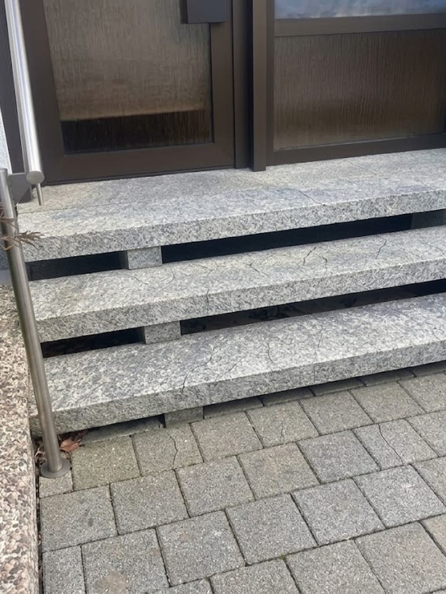 Eingangsstufen aus Granit mit feinen Rissen in den Trittflächen vor der Sanierung
