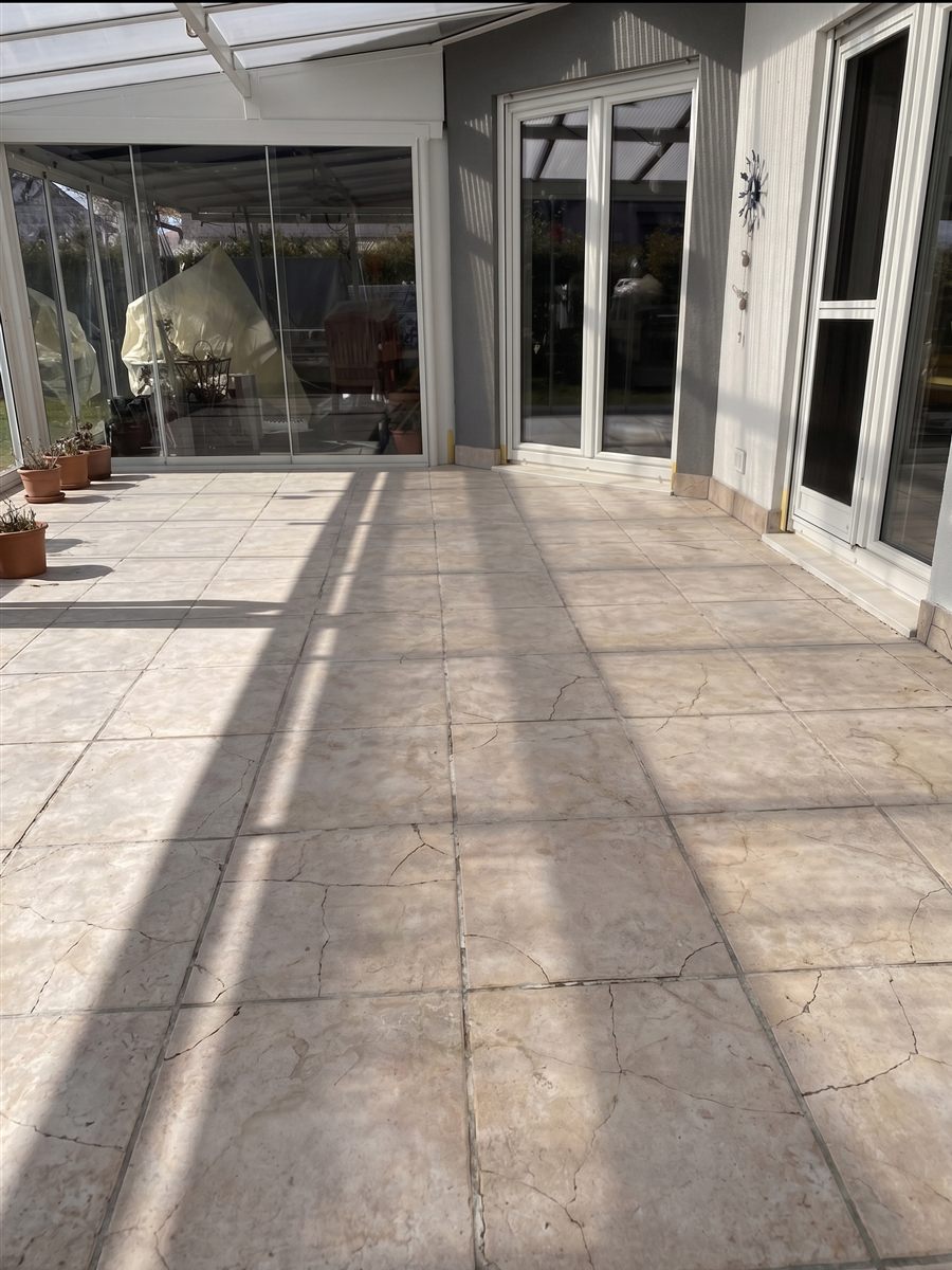 Terrasse mit gerissenen Fliesen vor der Sanierung